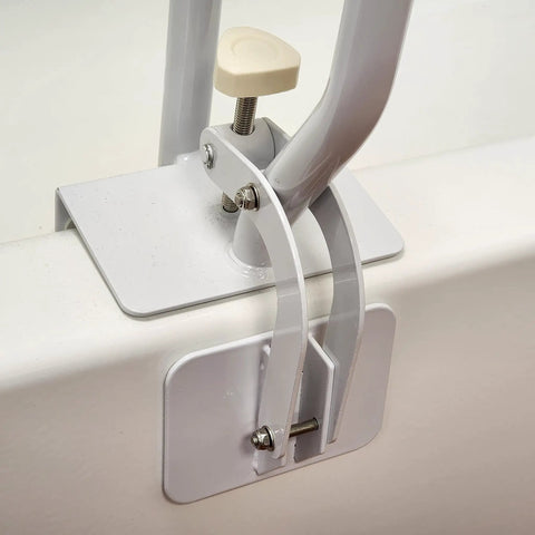 Close-up of white bathtub rail with wide grip for bathroom safety installed on tub edge, showing clamp mechanism for secure attachment.