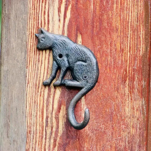 Heavy Duty Cast Iron Cat Wall Hooks Two Pack Featuring A Totally Badass Antique Dark Rust Finish Perfect For Holding Coats Keys And Furry Pet Leashes While Adding Killer Vintage Country Vibes To Your Space. Cat silhouette wall hook on wood background.