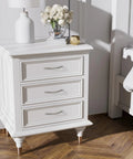 White dresser with three brushed nickel cabinet pulls, arch twisted design, placed in a bedroom setting with wood flooring.