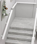 Rugged White Solid Wood Guardrail Loaded With Beefy Steel Brackets For Indoor Attic Or Stairway Safety Barrier Built Like A Tank Non Slip Grip Kid Approved Home Defense Six Point Six Feet Long installed on gray marble stairs.