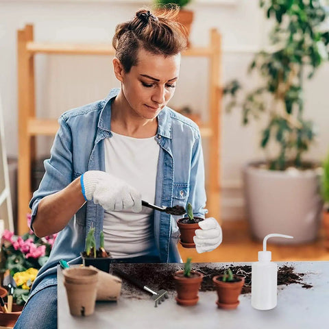 Person using the All-In-One Succulent Tools Set With 13-Piece Mini Garden Kit For Transplanting And Care indoors on small plants.