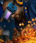 Man using Boss Grade Auto Darkening Welding Goggles Heavy Duty Industrial Safety Glasses With Lightning Shade Switch For Grinding Soldering And Precision Steel Fabrication In Navy Blue while working with sparks flying.