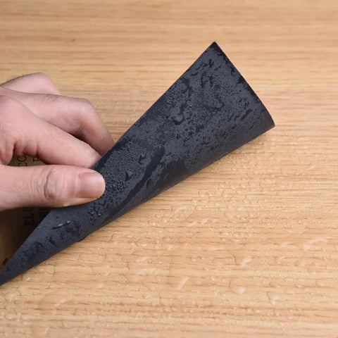 Hand holding Assorted Sandpaper Sheets 400 600 800 1000 1200 1500 Two Sheets Each Dry Wet Waterproof 9 x 3.6 Inch For Wood