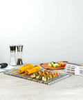 Foil Lux Disposable Grill Liners 19.7 By 12 Inch Nonstick Aluminum Grill Sheets next to grilled vegetables and corn on the counter