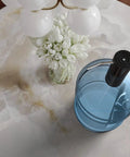 Electric USB Charged Water Dispenser Pump For 2 To 6 Gallon Bottles Portable Five Gallon Water Pump With One Touch Quick Pour Touch Activated Technology Keeps Hydration Easy on a marble table with flowers.
