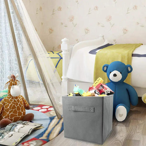 Three Pack Cube Storage Bins 9.0x7.5x7.5 Inches Foldable Fabric Closet Organizer in gray with toys in a nursery setting.