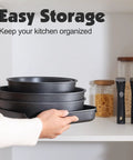 Person stacking Nonstick 17 Piece Pots And Pans Set With Removable Handles Induction Ready Cookware For RV And Home in cabinet
