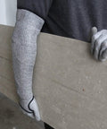 Person wearing Level 5 Cut Resistant Arm Sleeve With Thumb Hole No Slip, Heavy Duty Black Protective Sleeve, holding a large panel.