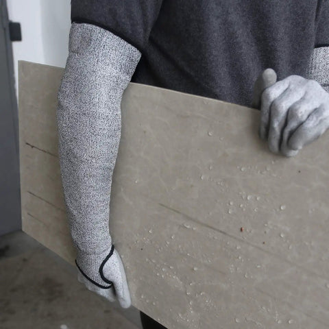 Person wearing Level 5 Cut Resistant Arm Sleeve With Thumb Hole No Slip, Heavy Duty Black Protective Sleeve, holding a large panel.