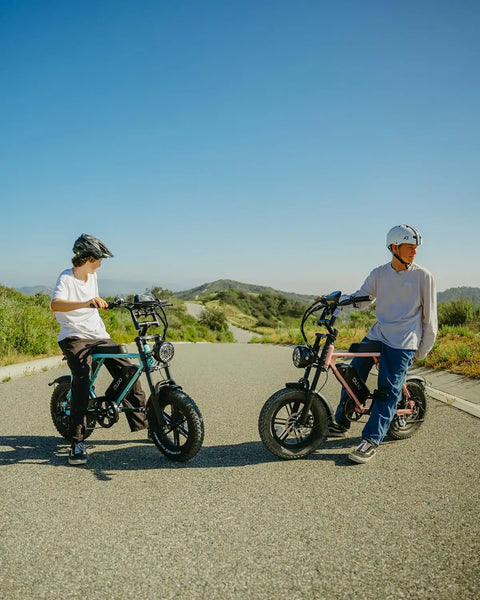 Two riders with Adult Electric Bike With 1000W Brushless Motor 20Mph Peak Pulls 16Inch Slick Wheels on an empty road.