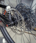 Magura MDR-C 203mm brake rotor, side view, mounted on bicycle disc brake; silver with cutouts