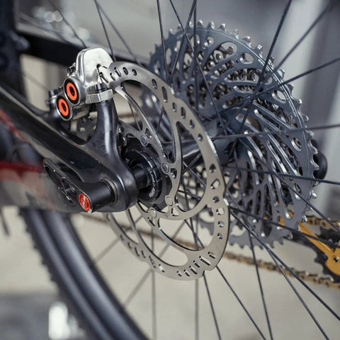 Magura MDR-C 203mm brake rotor, side view, mounted on bicycle disc brake; silver with cutouts