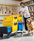 Person using 3 In 1 Aluminum Folding Hand Truck Dolly Cart With Wheels Up To 600 Lbs Capacity, carrying boxes in a workshop with a dog.