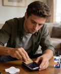 Man using Scratch Removal Kit For Screens And Glasses, 100Ml Repair Cream System to fix phone screen scratches in a living room.