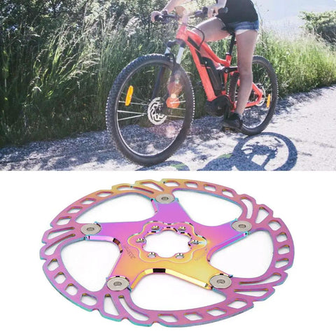 Person riding a mountain bike on a trail with Rock Solid Metal Disc Brake Pads For Mountain Bikes With Five Nail Design 203mm.