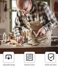 Man woodworking in workshop wearing plaid shirt and apron; focus on precision craft with tools on the table.