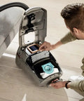 Person replacing Active AirClean Filter SFAA50 For Miele Vacuum Cleaners with TimeStrip HEPA Filtration in open vacuum cleaner