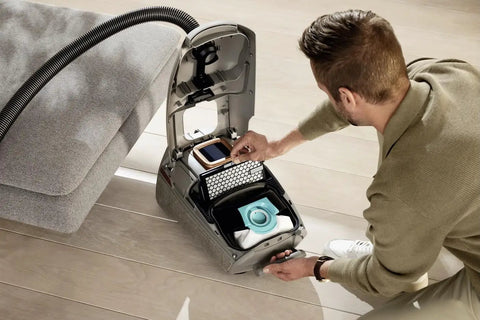 Person replacing Active AirClean Filter SFAA50 For Miele Vacuum Cleaners with TimeStrip HEPA Filtration in open vacuum cleaner