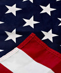 Close-up of Outdoor 3x5 American Flag Made In USA With Brass Grommets Built To Last Outdoors Polycotton For Exterior Use 100 Percent Made In USA Flag With Vivid Red And Deep Blue Colors Weather Resistant FMAA Certified.