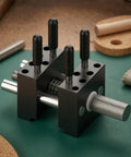 Compact Handheld Metal Vise With Multi Peg Holes For Precision Model Work And Desktop Clamping Projects, Durable Black Mini Bench Tool For Crafters on green workbench.