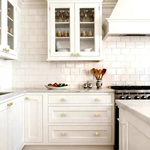 10 Pack Brushed Gold Cabinet Knobs With Ribbed Zinc Alloy Hardware in a modern white kitchen with drawers and cabinets.