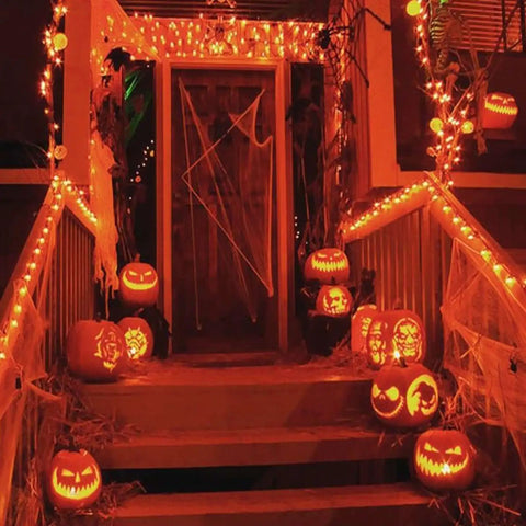 Front porch decorated for Halloween with jack-o'-lanterns and Two Pack Solar Christmas String Lights With Remote And Timer in warm white.