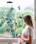 Outdoor Wind Chimes And Hummingbird Feeder Duo For Your Garden Vibes hanging outside a window with hand-blown glass globes.