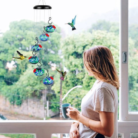 Outdoor Wind Chimes And Hummingbird Feeder Duo For Your Garden Vibes hanging outside a window with hand-blown glass globes.