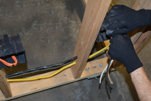 Installer wiring 25 Ft 6-3 NM-B Cable NMWG Ground For Residential In-Wall Wiring, showing hands connecting cables in wood frame