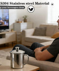Solid Stainless Steel Universal Mug Lid keeps your morning grind hot and clean with ergonomic grip on a coffee table.