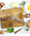 All In One Multifunction Garden Hand Tool Potting Soil Scoop Bean Sprout Fork on a cutting board with kitchen items