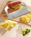 Angled front view of Zorveiio stainless steel crinkle cutter with wooden handle on cutting board; ridged wavy blade.