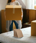 Person holding a box with Corrugated Paper Filler Sheets 20x20cm 12 Pack for Cardboard Boxes Protective Insert Pads on bed