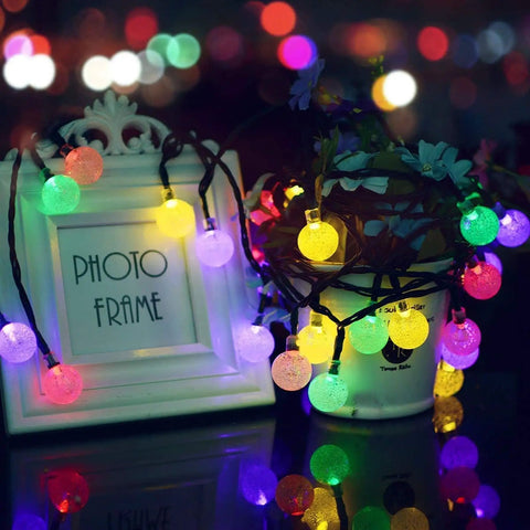Solar Outdoor String Lights With 60 LED Crystal Globe Bulbs 8 Modes 26ft Waterproof Fairy Lights illuminating in darkness