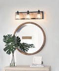 Three-Light Bathroom Vanity Light 23 Inch Large Fixture With Bubble Glass Shades over a round mirror and plant decor