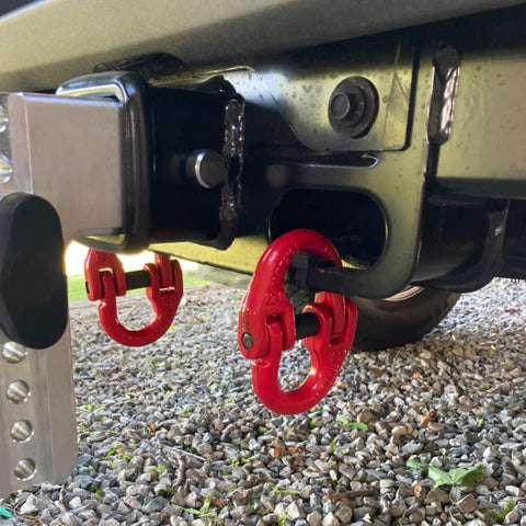 Heavy Duty Alloy Steel Coupling Links 4 Pack 1/4 Inch Grade 80 Hammer Lock Chain Connectors attached to a trailer hitch.