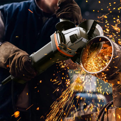 Angle grinder in use cutting a metal pipe; worker wearing gloves as sparks fly.