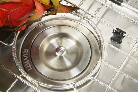 Close-up of a stainless steel drain in a 13x15 Inch Undermount Bar Sink For Small Kitchens, 16 Gauge with brushed finish and fruit