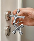 Hand holding TwinKey Multifunctional Spanner Kit with Magnetic Eight Arm Two By Four Way Spider Keys, near a control cabinet lock.