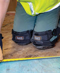 Person wearing All Day Comfort Hinged Gel Knee Pads With Slip Resistant Rubber Caps, Quick Release Clips And Adjustable Straps on wooden floor.