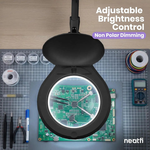 Pro Grade LED Magnifying Lamp With Clamp, 6 Inch Glass Lens, illuminating a circuit board, showcasing nonpolar dimming feature.