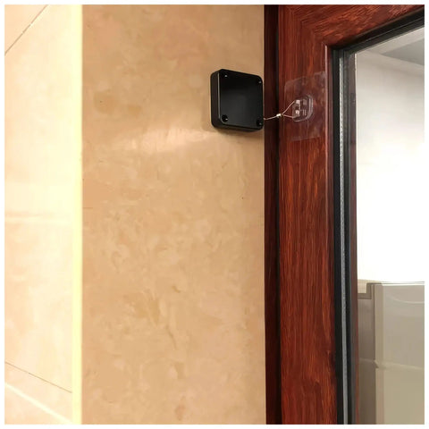 Image of No-Drill Sensor Door Closer, 1-Piece Slim Black on wooden door frame with pull cord for auto soft close.