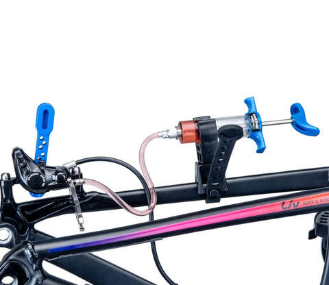 BKM12 Hydraulic Brake Bleed Kit For Mineral Oil With Dual Syringes attached to bike frame for bleeding purpose