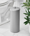 Discreet Floor Standing Toilet Paper Holder With Lid For 3 Extra Rolls In Silver beside a toilet in bathroom.