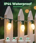 Vintage Clear C9 Christmas String Lights 100 Ft Outdoor Waterproof Lights With 100 Glass Bulbs On Green Wire on wet white fence.