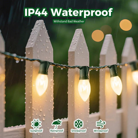 Vintage Clear C9 Christmas String Lights 100 Ft Outdoor Waterproof Lights With 100 Glass Bulbs On Green Wire on wet white fence.