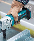 Worker using 18V LXT Cordless 16 Gauge Metal Nibbler, Tool Only, 1,900 SPM, Rotating Die Holder 360 Degrees on metal sheet