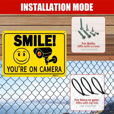 Two Pack Smile Youre On Camera Signs 10 By 7 Inch Funny Security Signs With Smile Face And Camera Icon Rust Free Aluminum UV Printed And Weatherproof Surveillance Signs For Business Home And Office mounted on fence with installation instructions