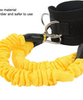 Close-up of yellow latex ankle straps with cuffs for resistance training, featuring dual D-ring attachments for stability.