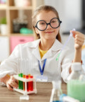 Child in Kids Scientist Costume Lab Coat With Goggles Glasses ID Card And Gloves For Pretend Play Hands On Science Projects Career Day And Halloween Dress Up For Boys And Girls XL Size, holding a pipette, next to test tubes.